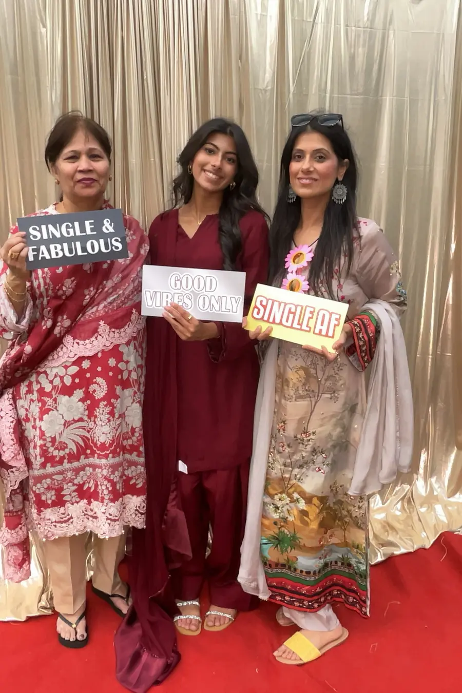Friends holding playful photo booth signs