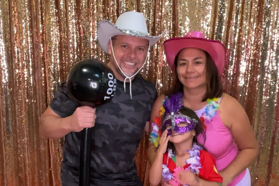 A family posing with a costume mask and props at a party
