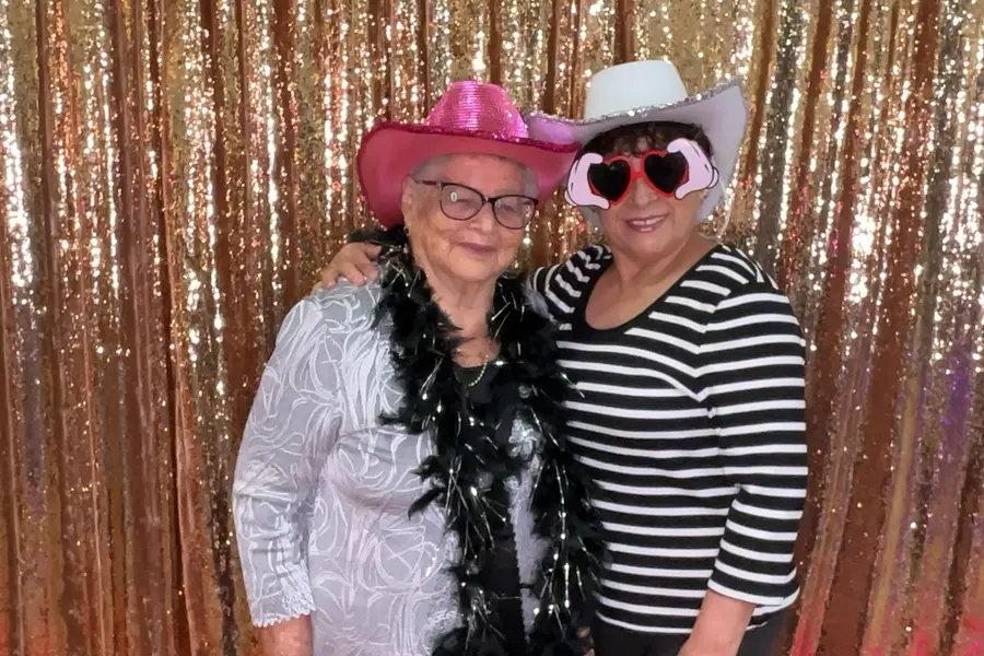 Two guests posing with cowboy hats at a party
