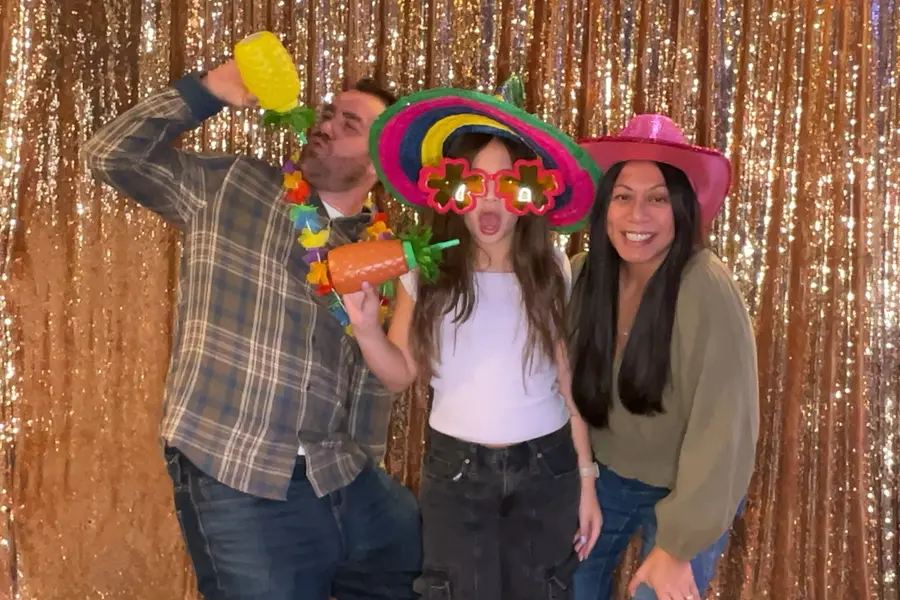 A father and son posing with tropical party props