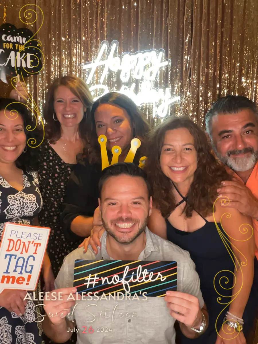 Friends posing with funny signs at a sweet sixteen party