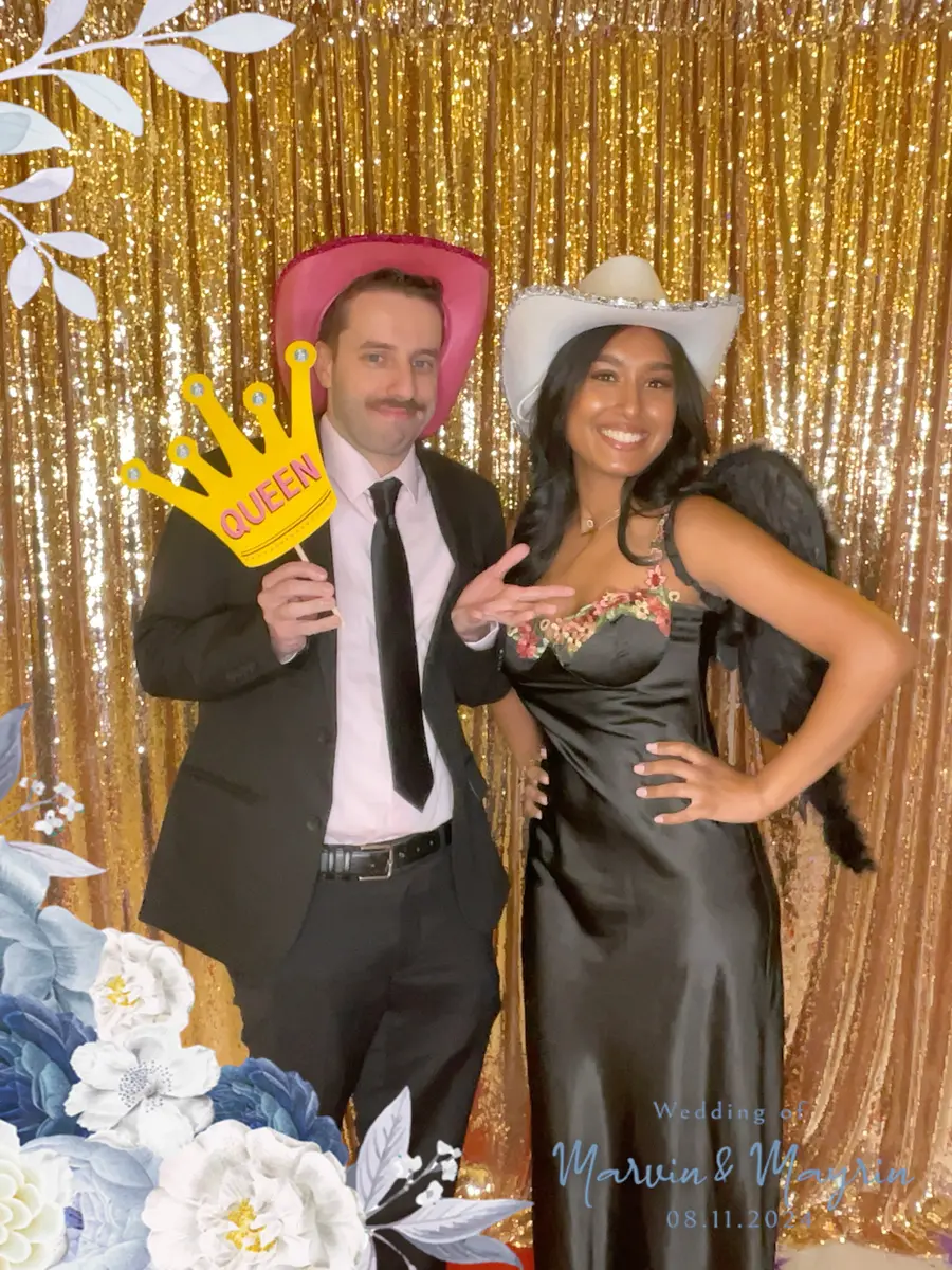A couple posing with a crown prop at a wedding